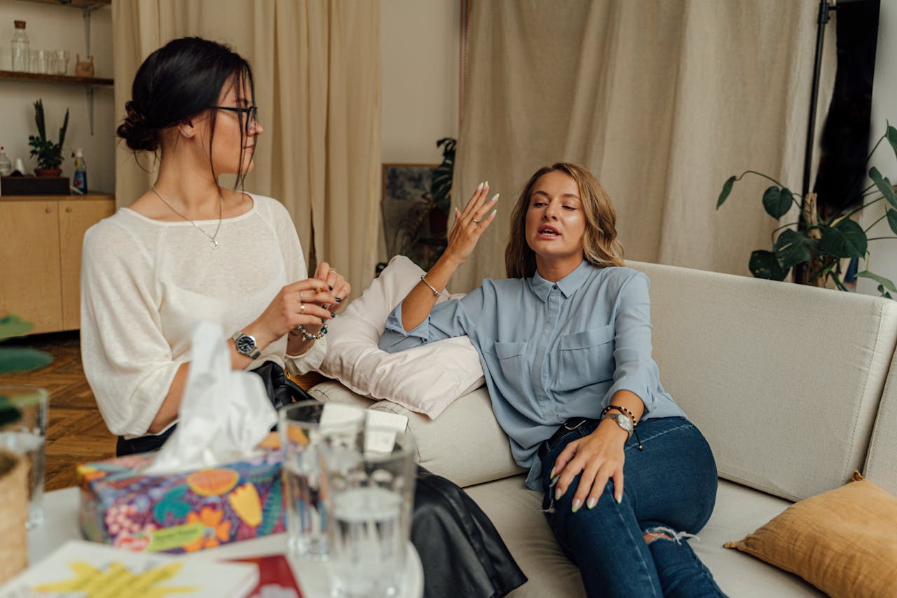 hero-img-02 A counseling session with two women engaged in conversation on a comfortable sofa.